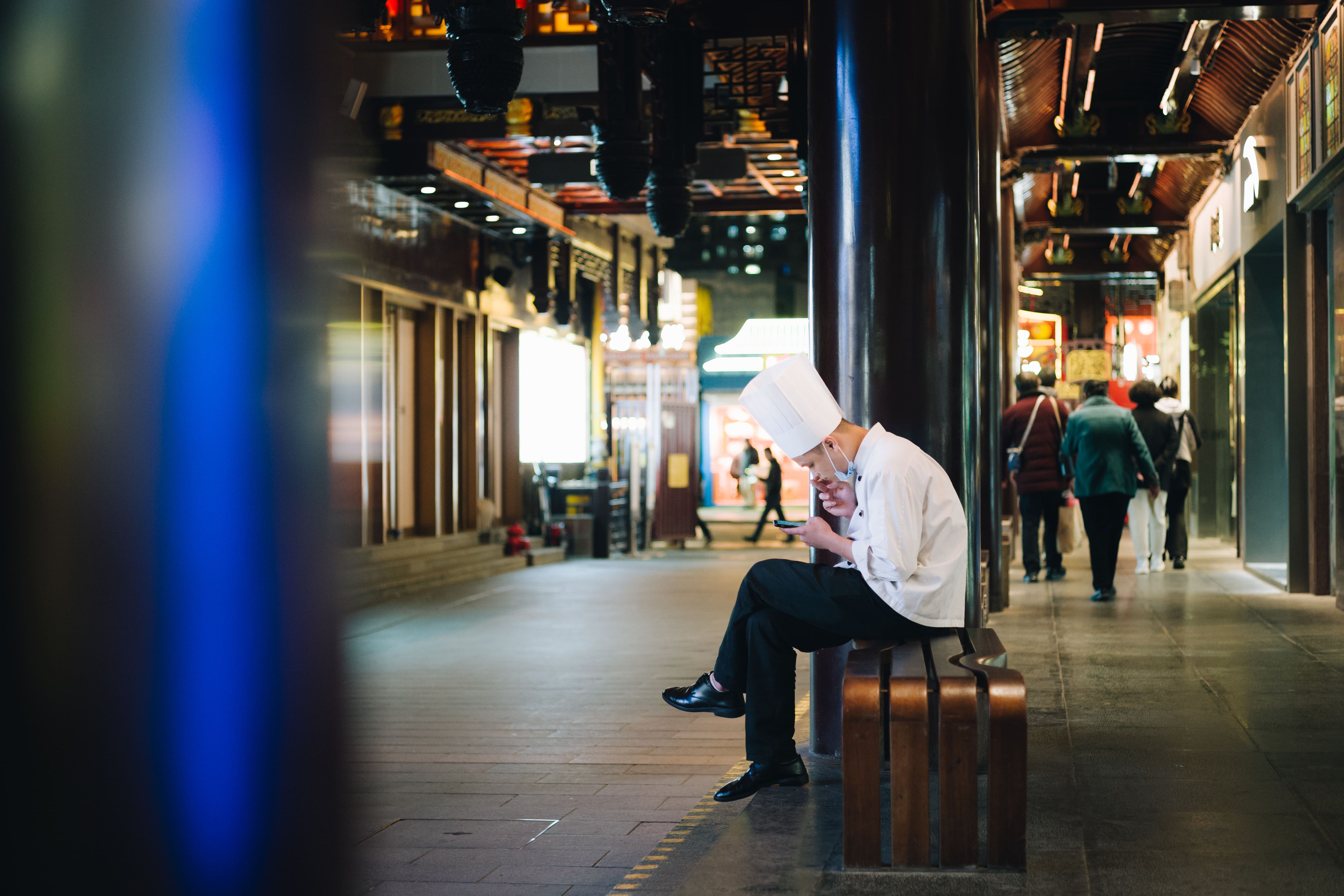 回廊で一息つく若いコック
